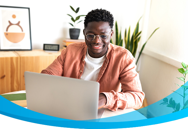 Happy young man uses laptop with fast internet.