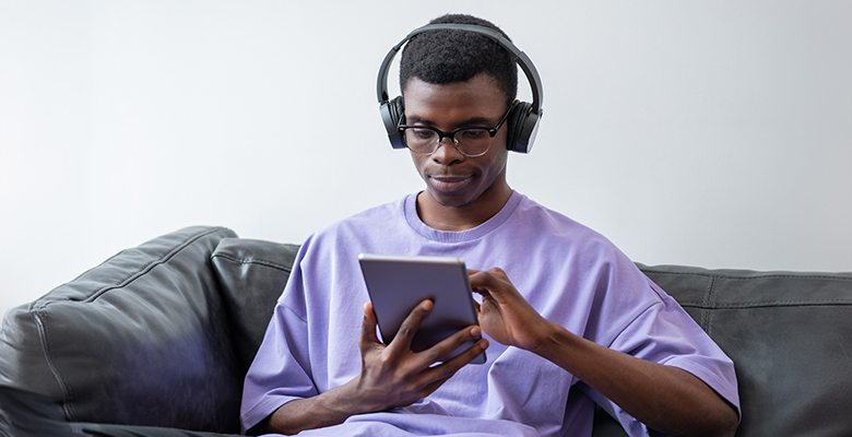 Man uses tablet at home with fast fiber internet.