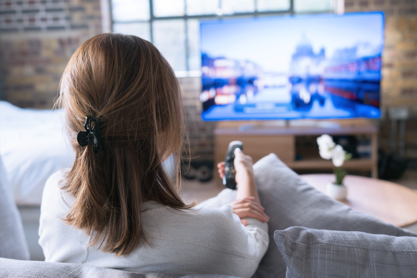 Vista posterior de una mujer viendo la televisión
