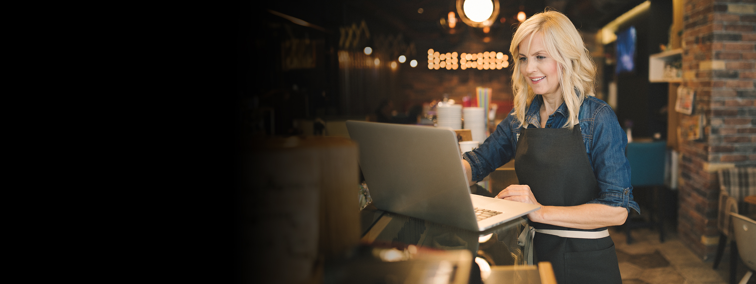 Coffee shop owner working on laptop