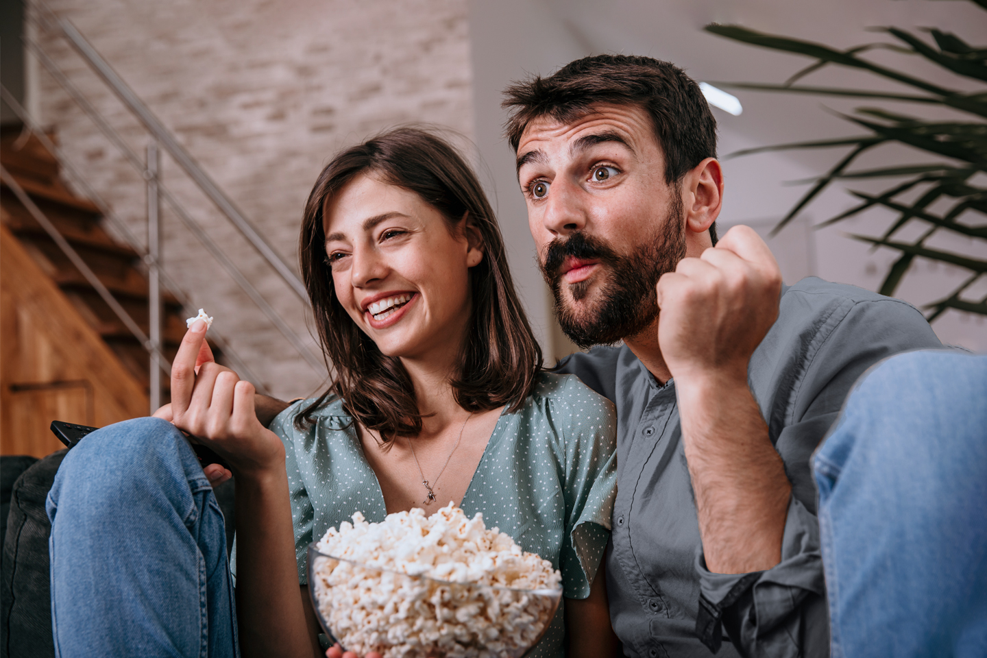 Pareja emocionada viendo televisión juntos