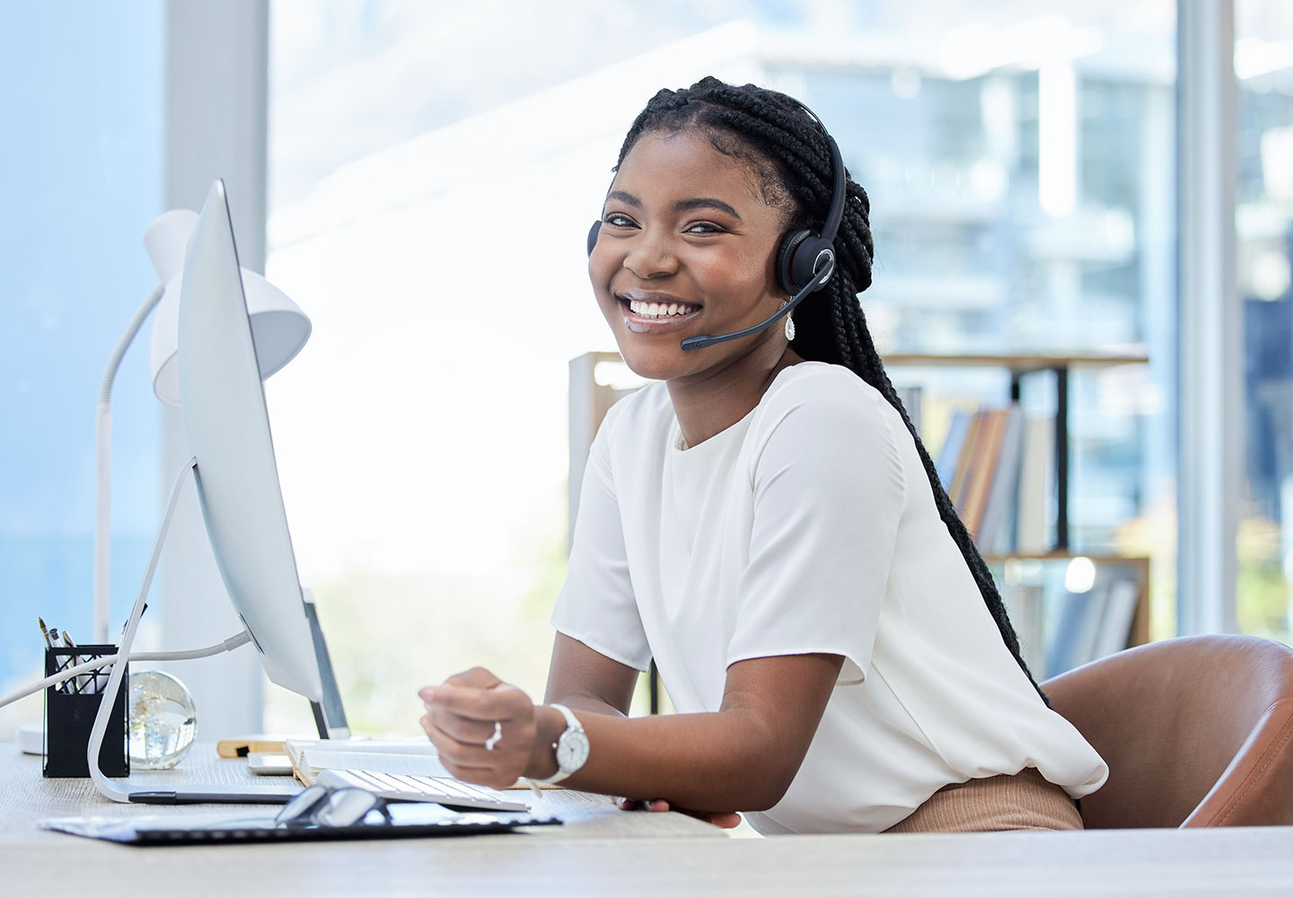 Woman wearing headset, sitting at desk