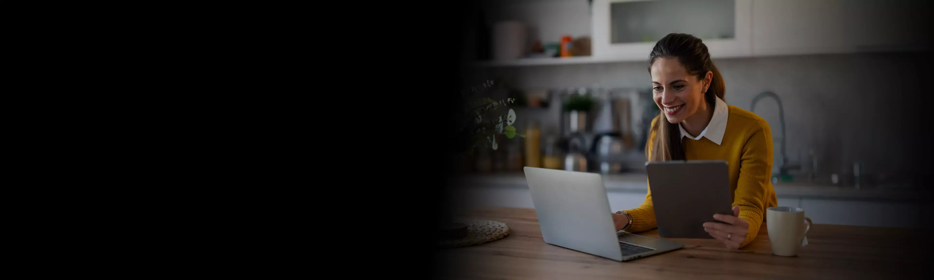 Happy woman uses laptop and tablet with fast internet at home.