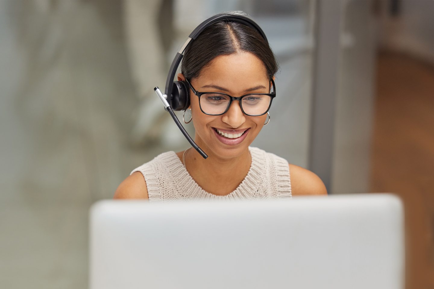 Agente de servicio al cliente ayudando a alguien con sus auriculares y su computadora.