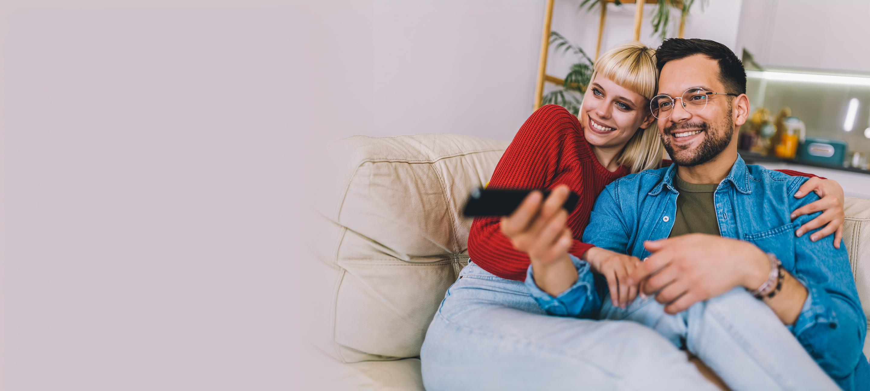 Happy couple watches tv at home.
