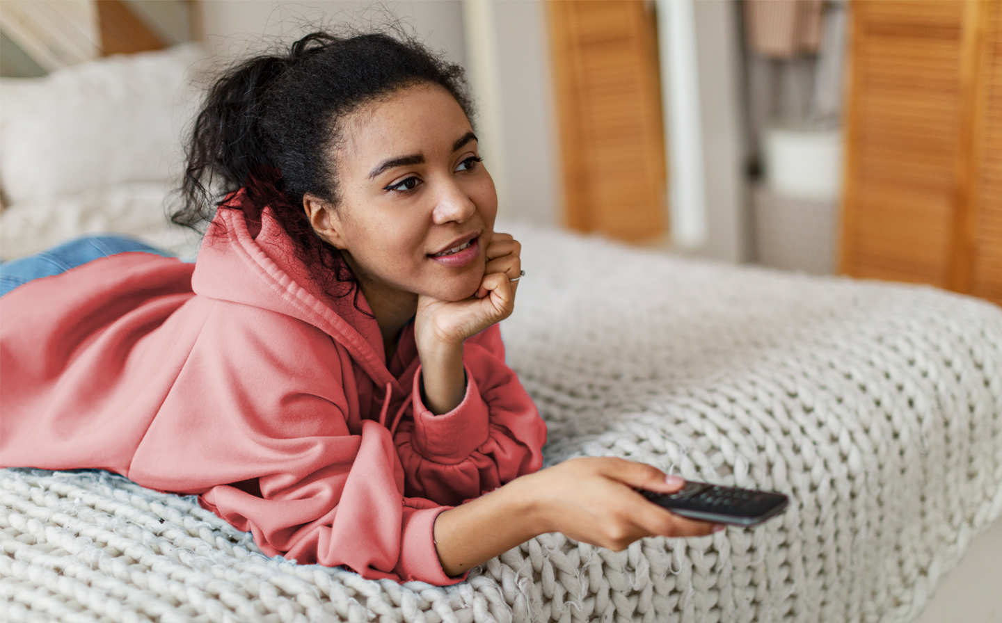 Girl in pink hoodie watching TV