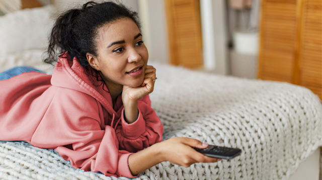 Girl in pink hoodie watching TV