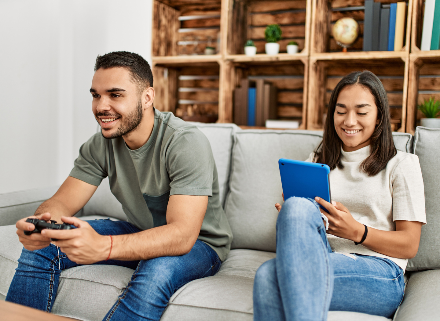 Chico y chica disfrutando de Internet de fibra de alta velocidad mientras usan sus dispositivos. Boy and girl enjoying there high speed fiber internet while using their devices.