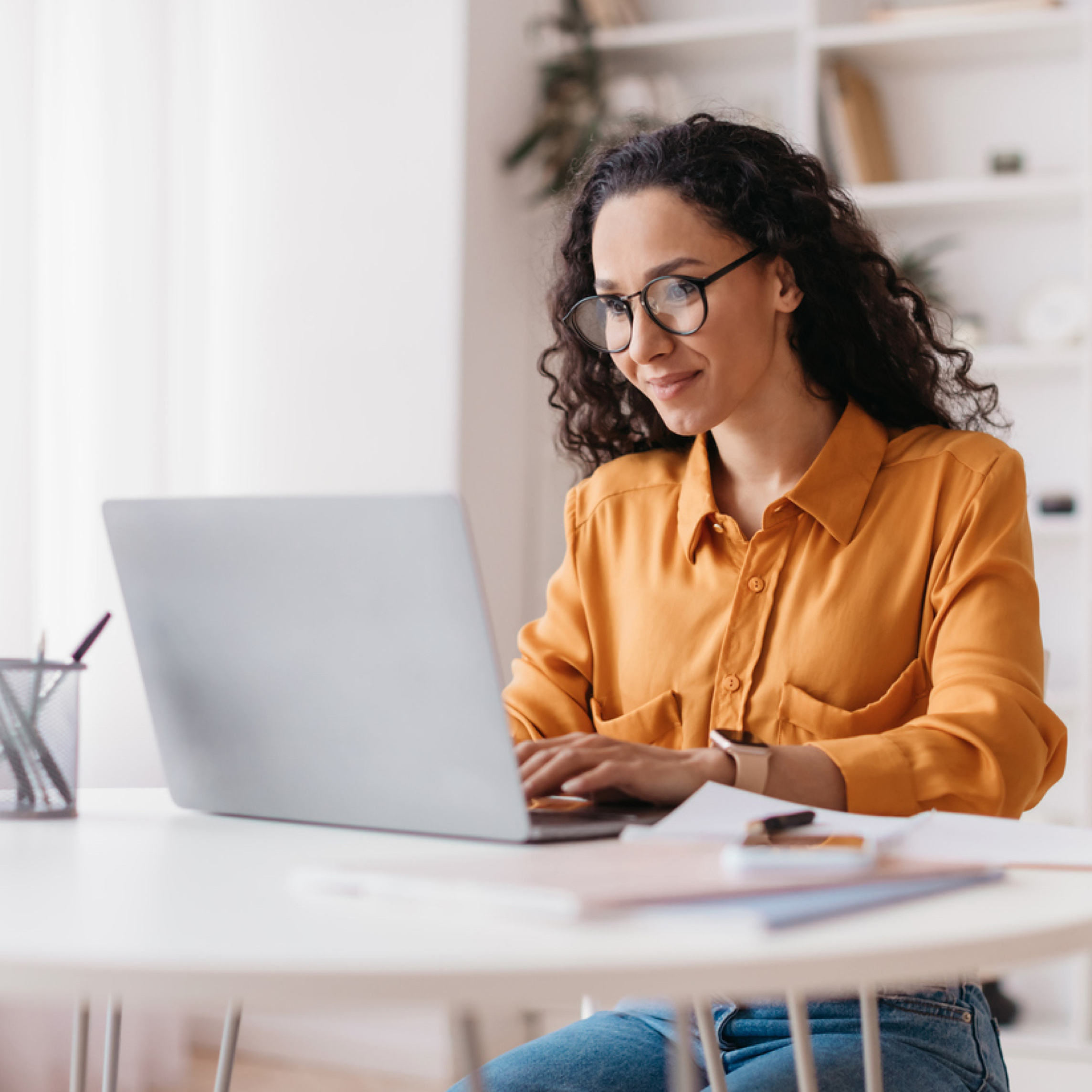 Woman works on laptop at home.
