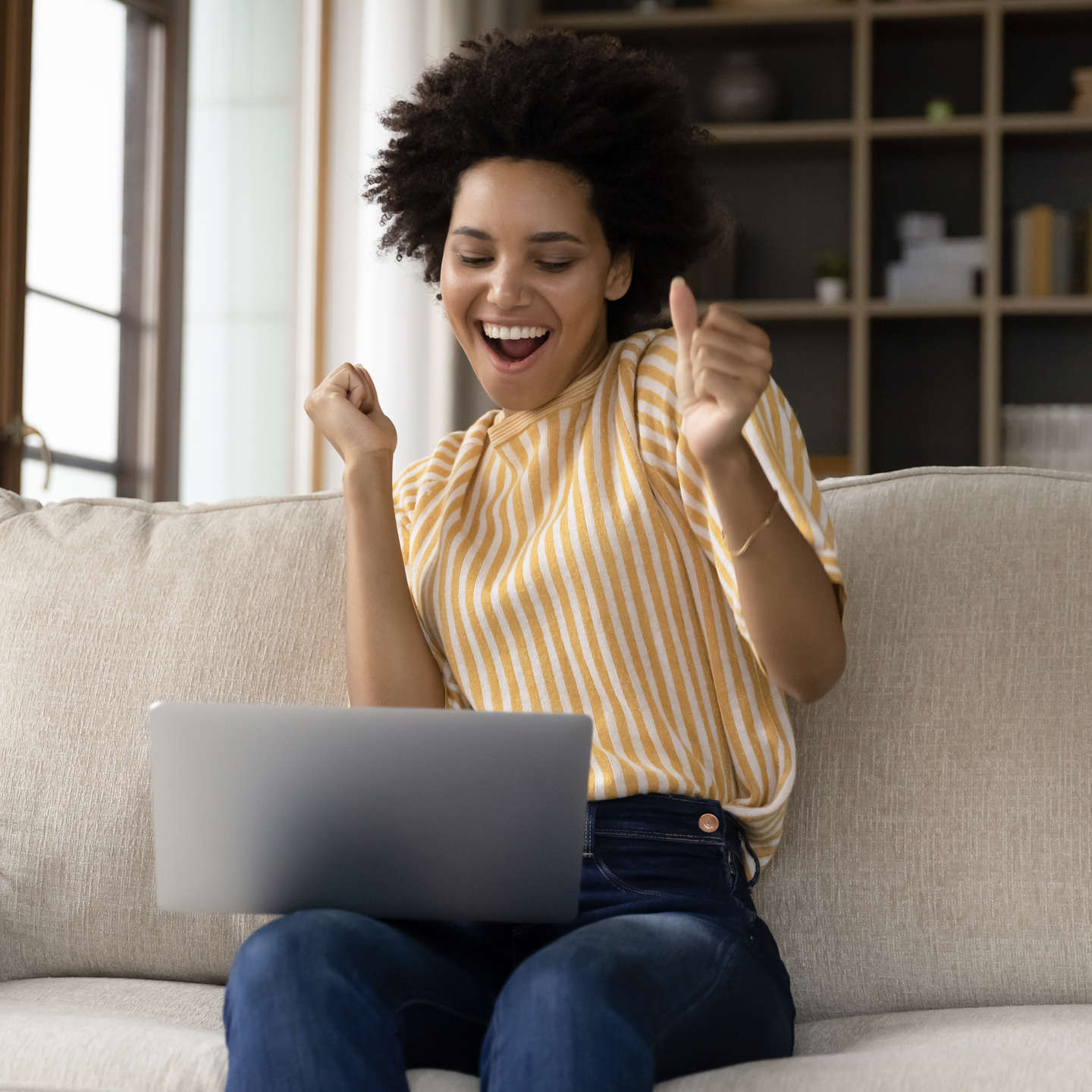 woman celebrating on a sofa
