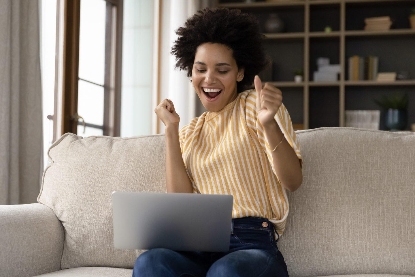 woman celebrating on a sofa