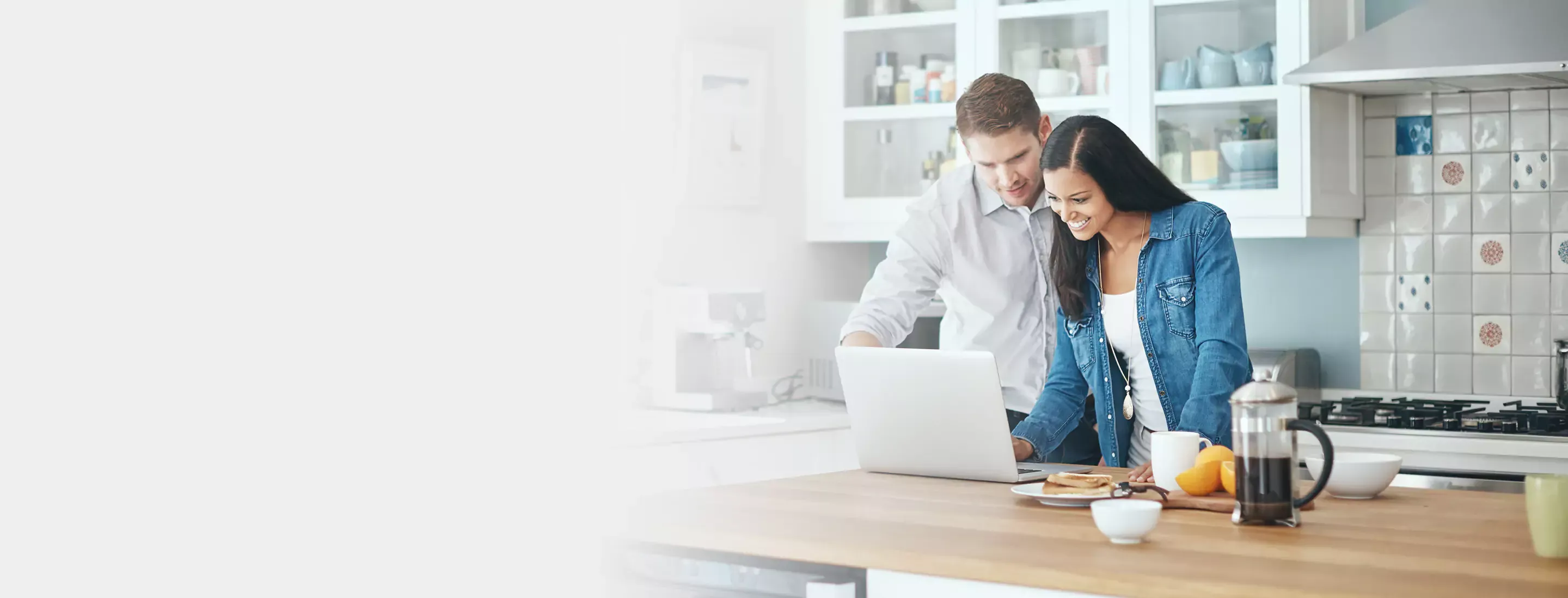 a couple using laptop in kitchen