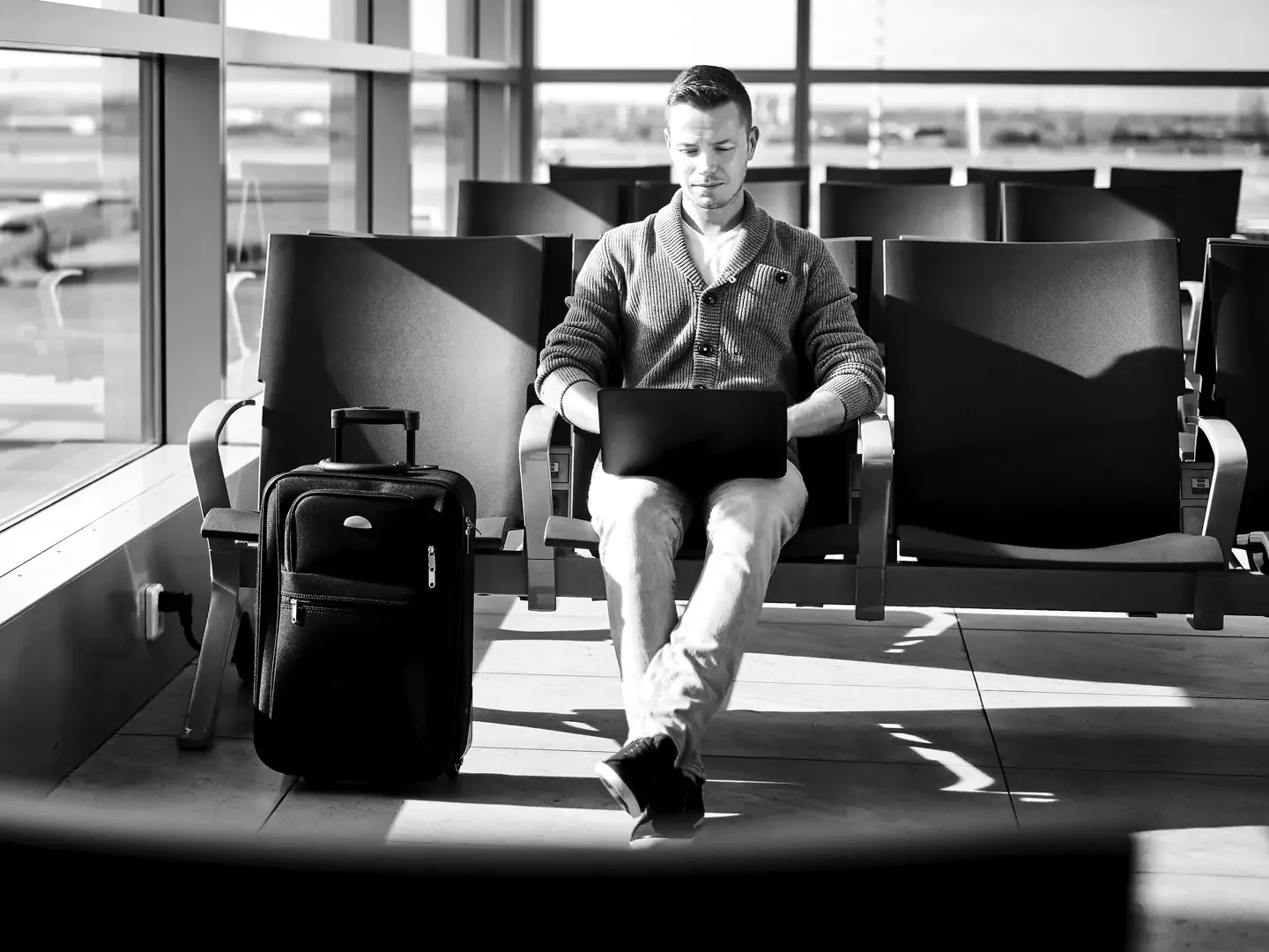 Man working at his laptop while waiting for his flight.