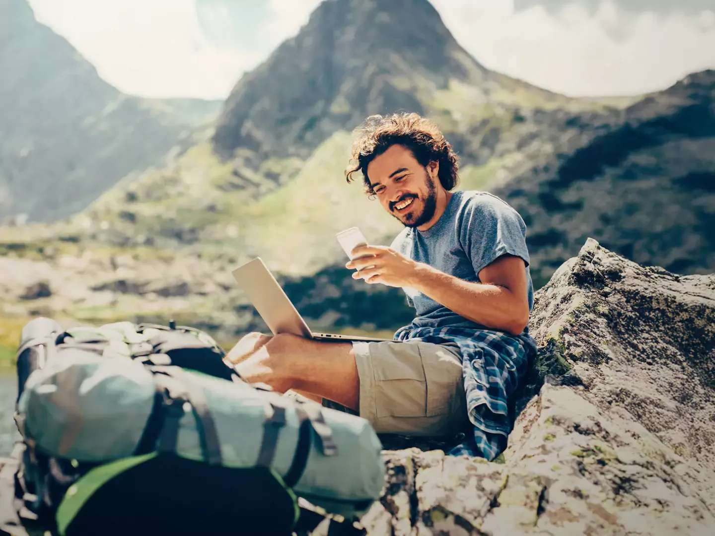 Man getting some internet time while up in the mountians.