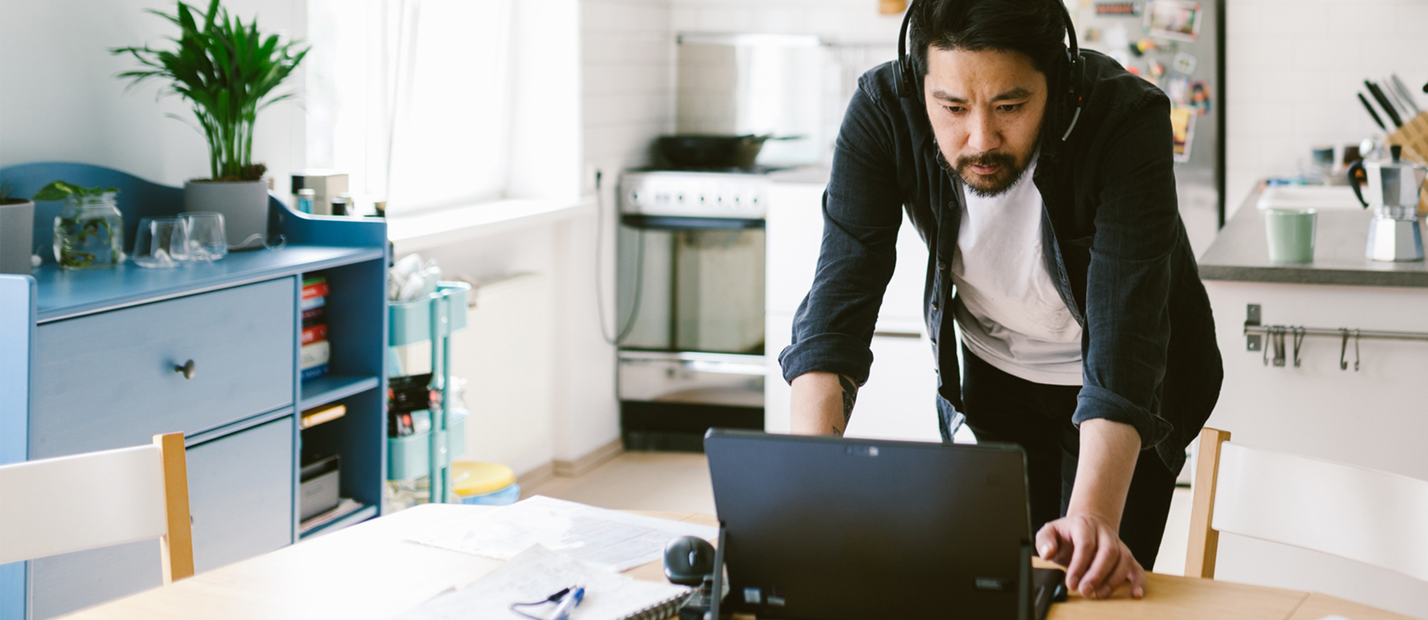 Man looking at laptop while wearing headphones