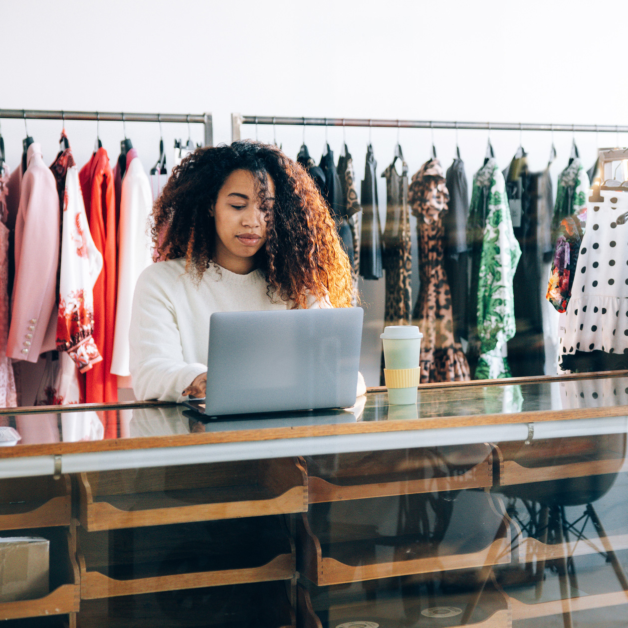 Small business owner working on computer in her clothing shop