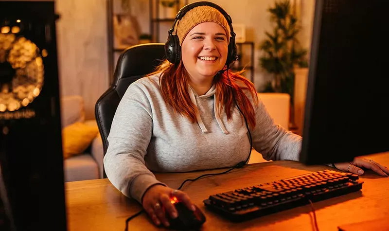 Closeup of woman wearing a beanie and gaming at home with Fiber internet