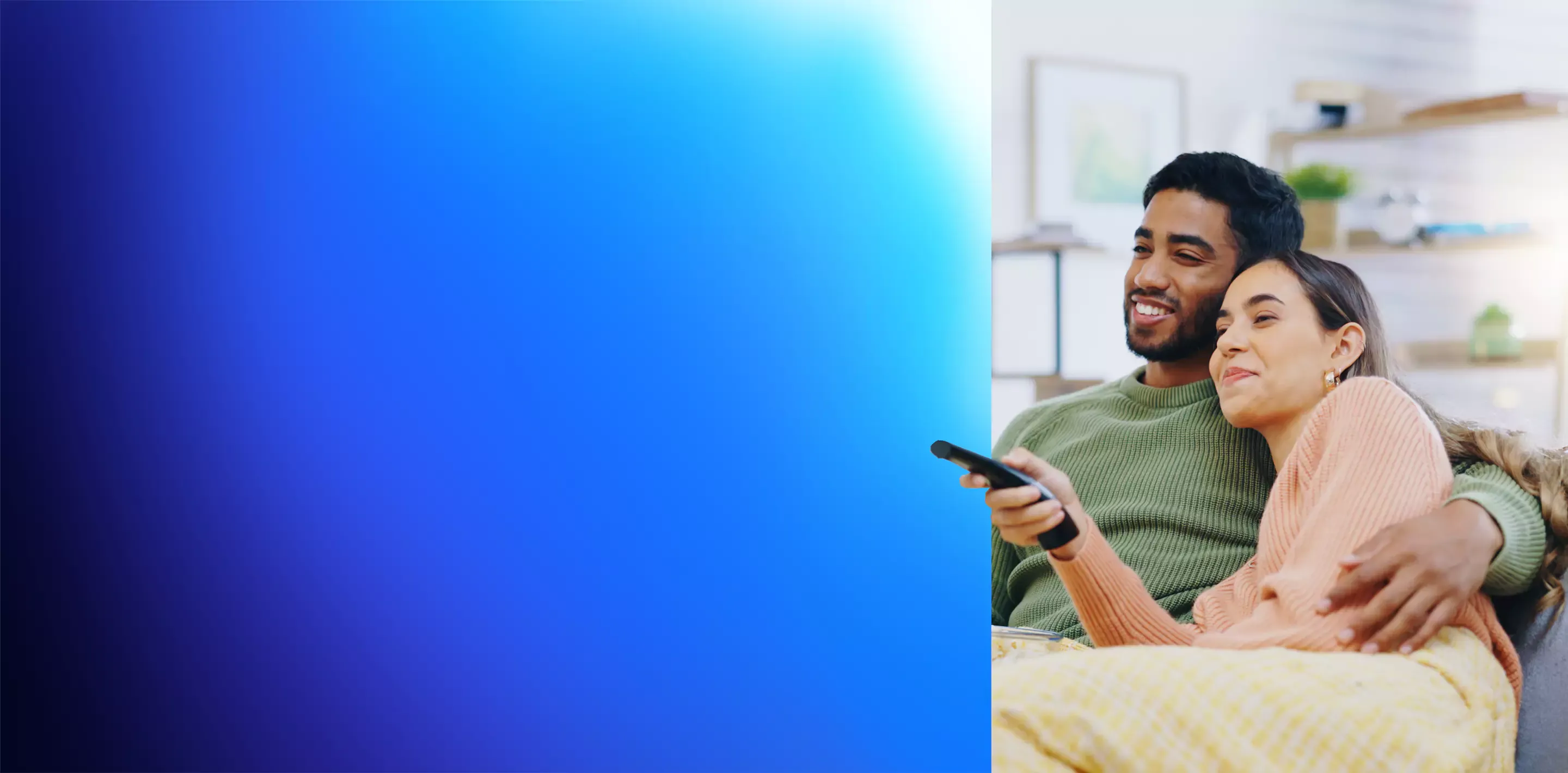 Couple on the sofa embracing and watching the TV