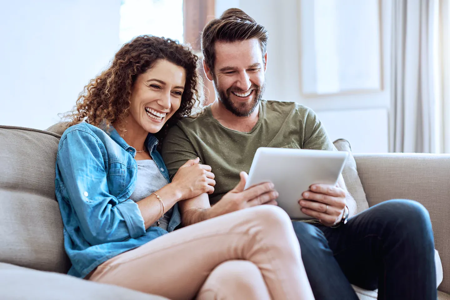 Couple searching the internet on the couch.