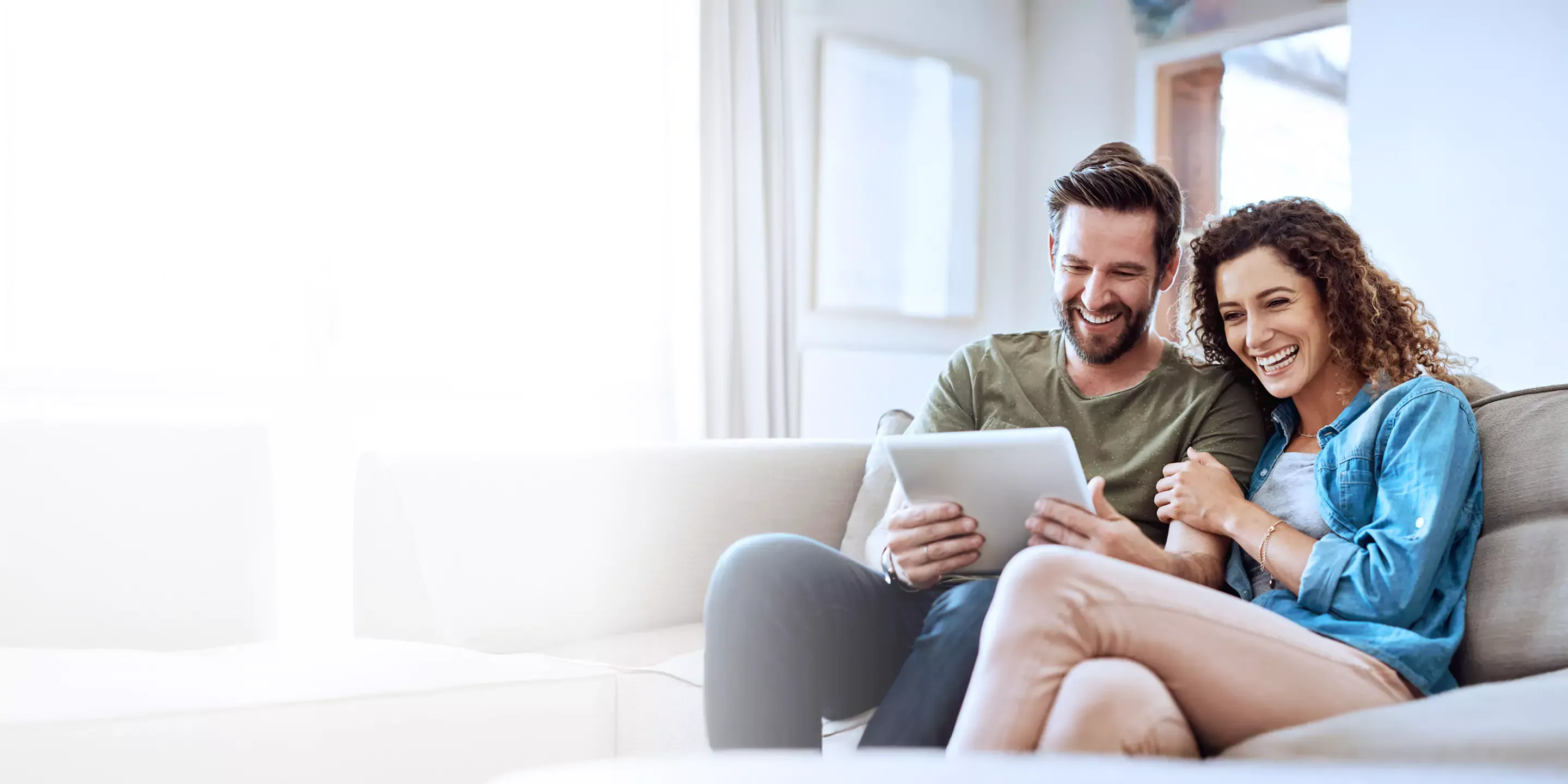 Couple searching the internet on the couch.