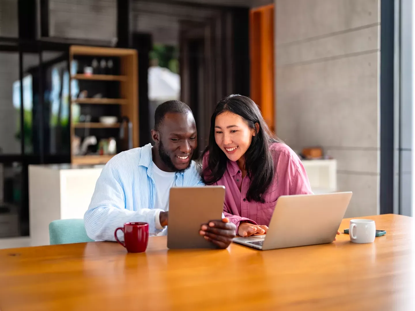 Man and woman reviewing their bills online on their laptop and tablet.
