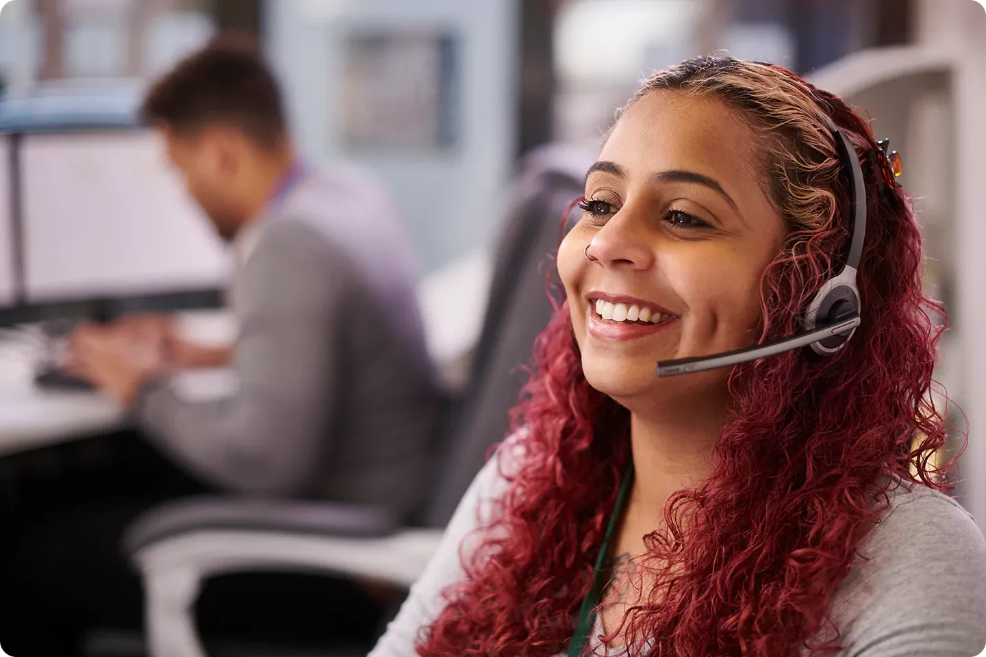 Customer Service representative smiles as she talks on the phone.