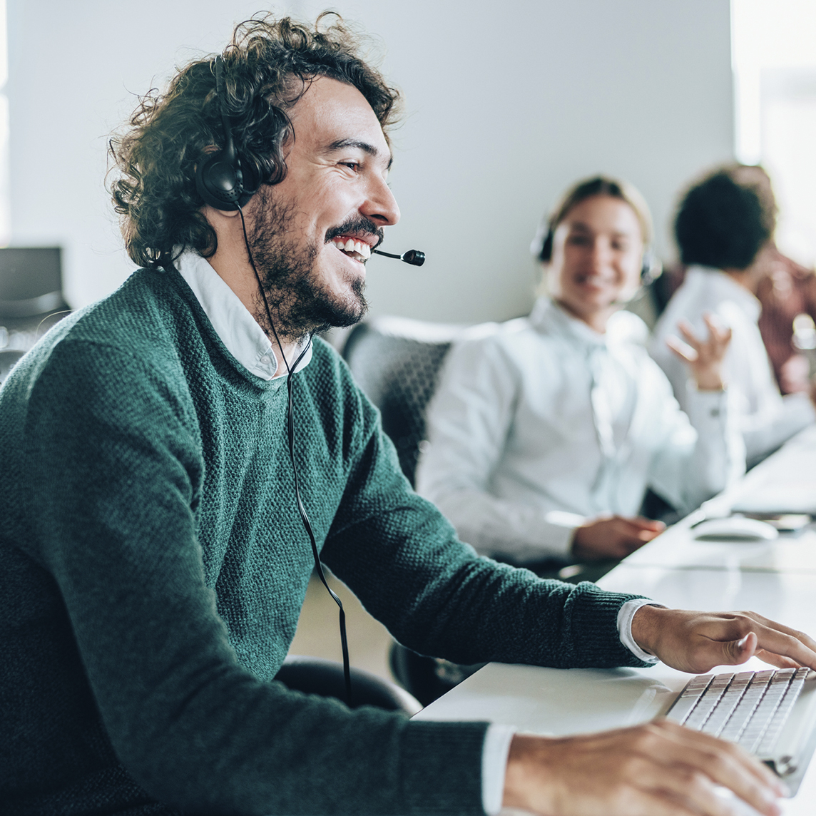 Row of customer service agents talking on phone