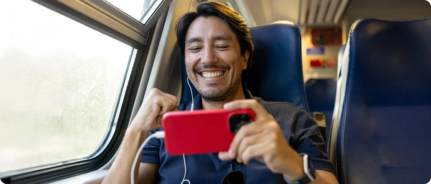 Man watches TV on train with DirecTV App.