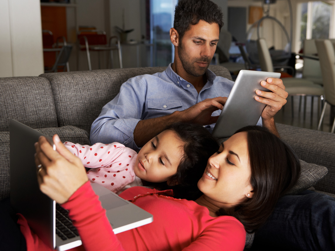 Familia de tres usando dispositivos