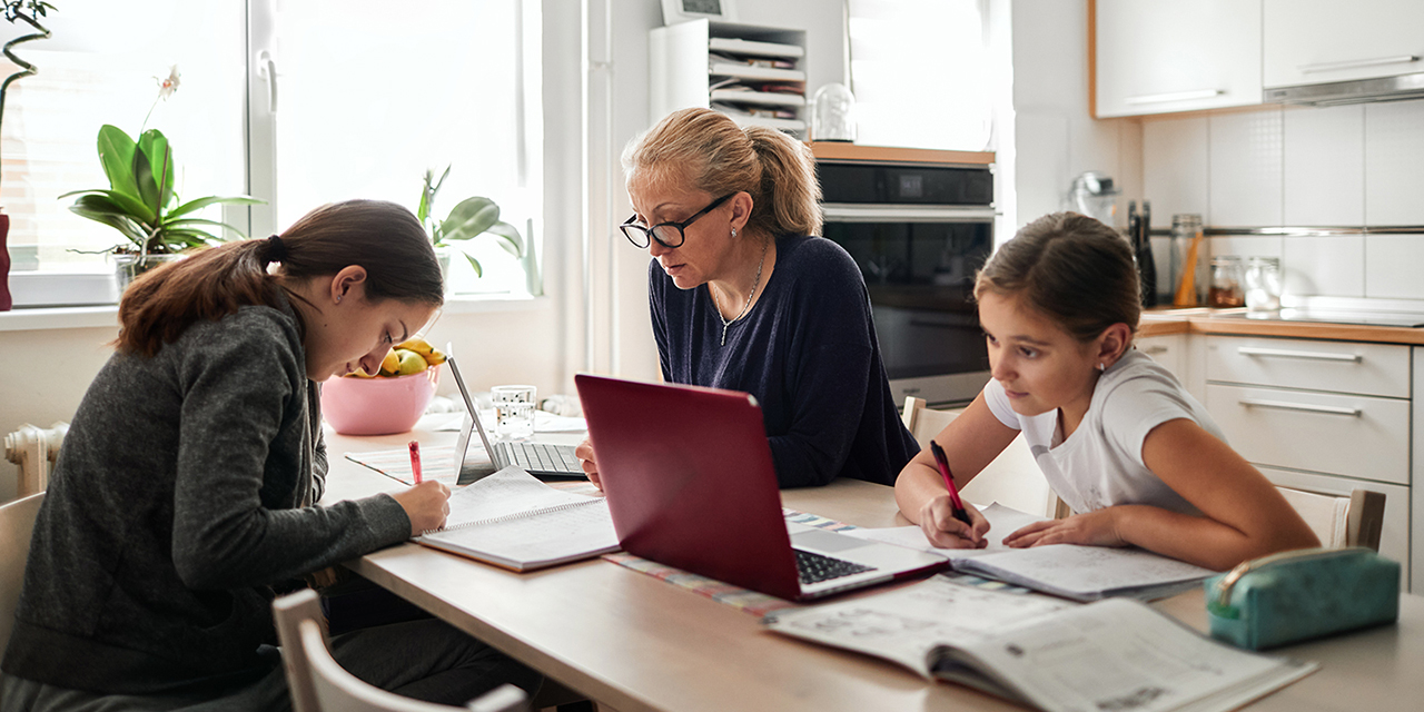 Family at a kitchen table using CenturyLink internet to do homework.