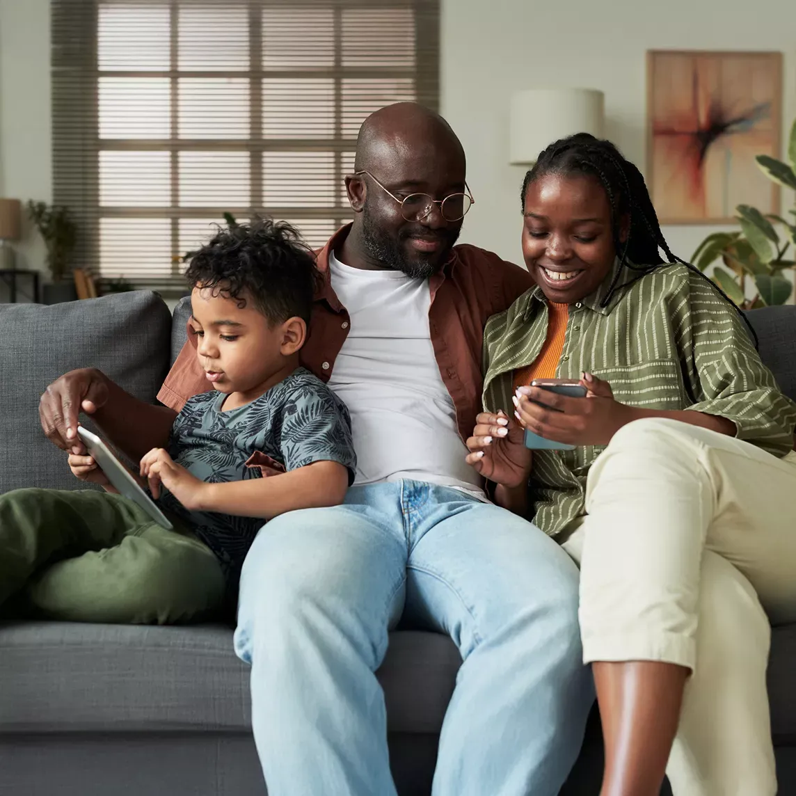 Family uses devices together on couch