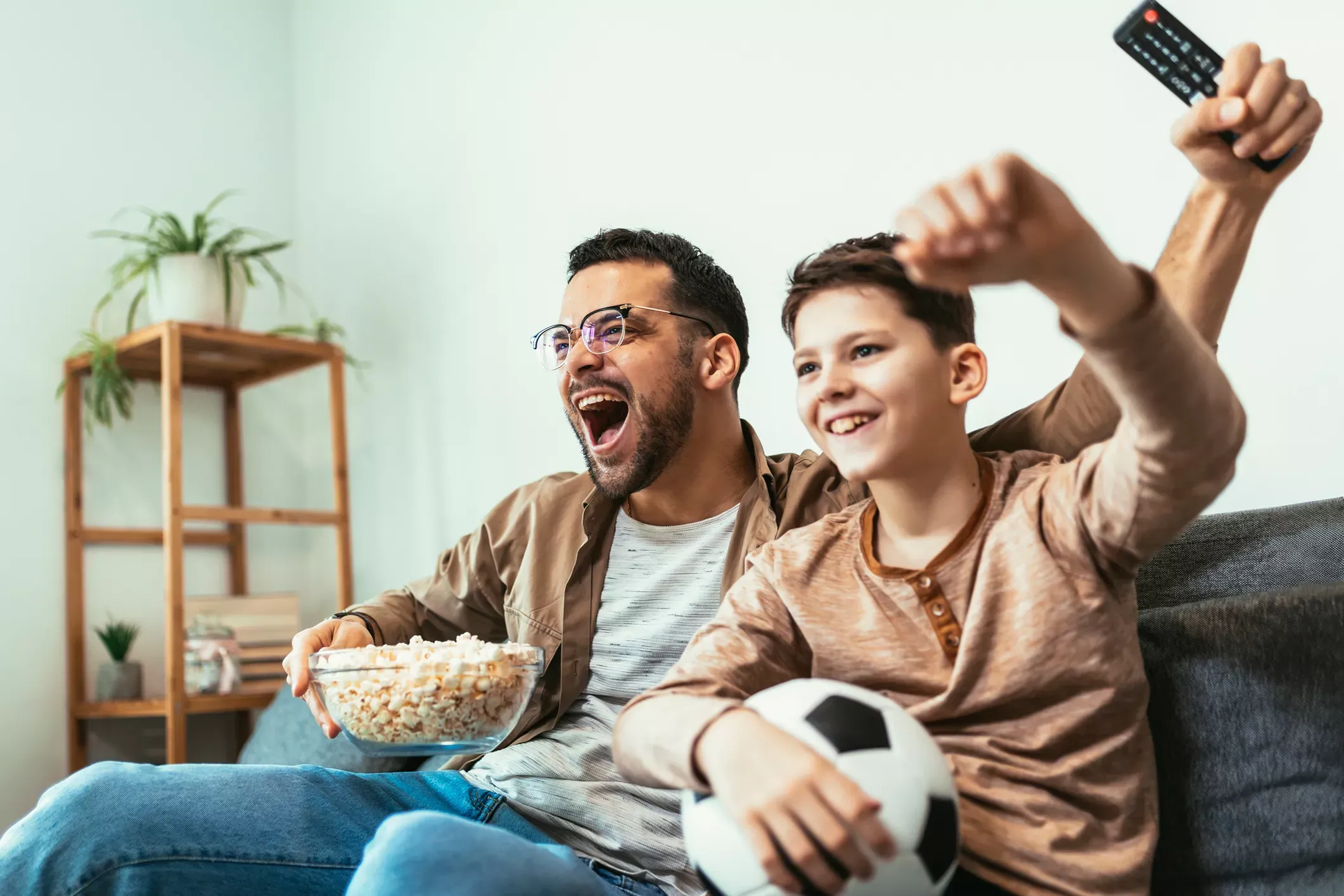 Father and son watch sports on TV