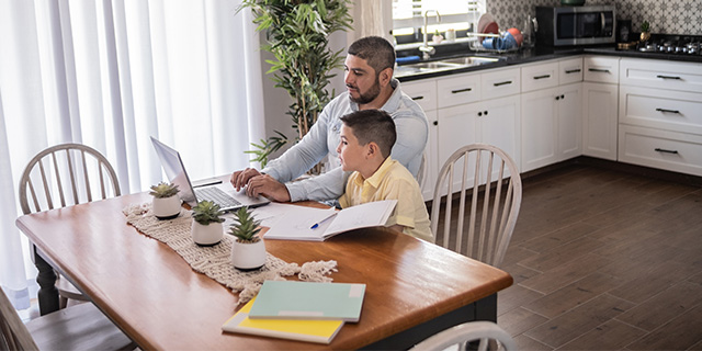padre e hijo usando una laptop para la tarea
