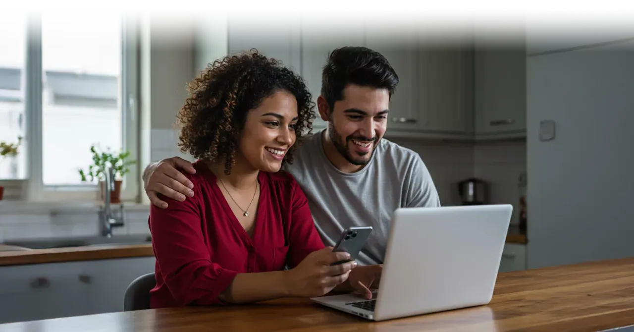 Una pareja usando internet en la encimera de la cocina.