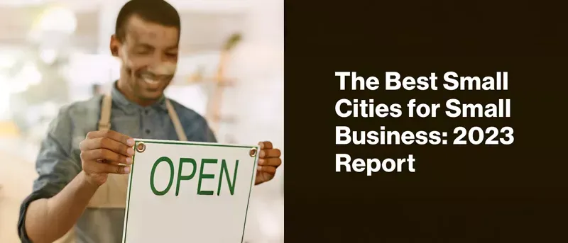 Man holding the open sign at his small business.