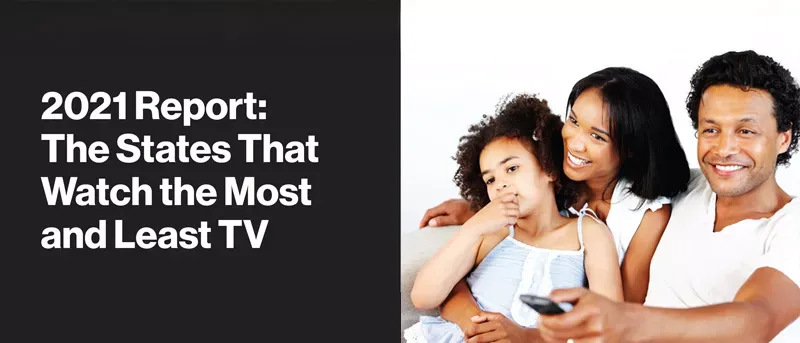 Smiling family watching TV together.