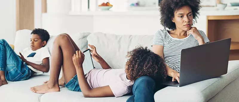 Family on the couch using multiple devices.