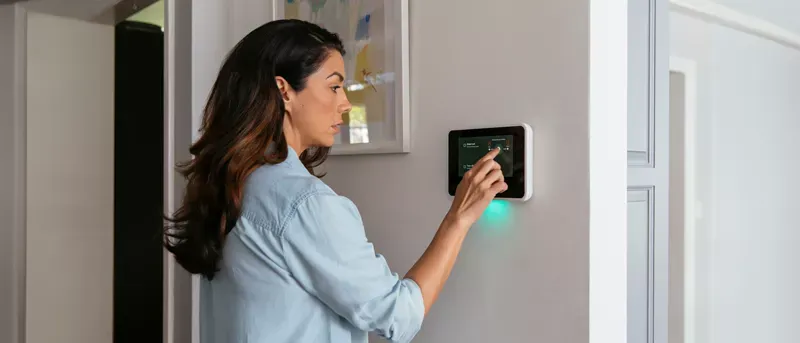 Woman turning off her triggered smart home alarm.