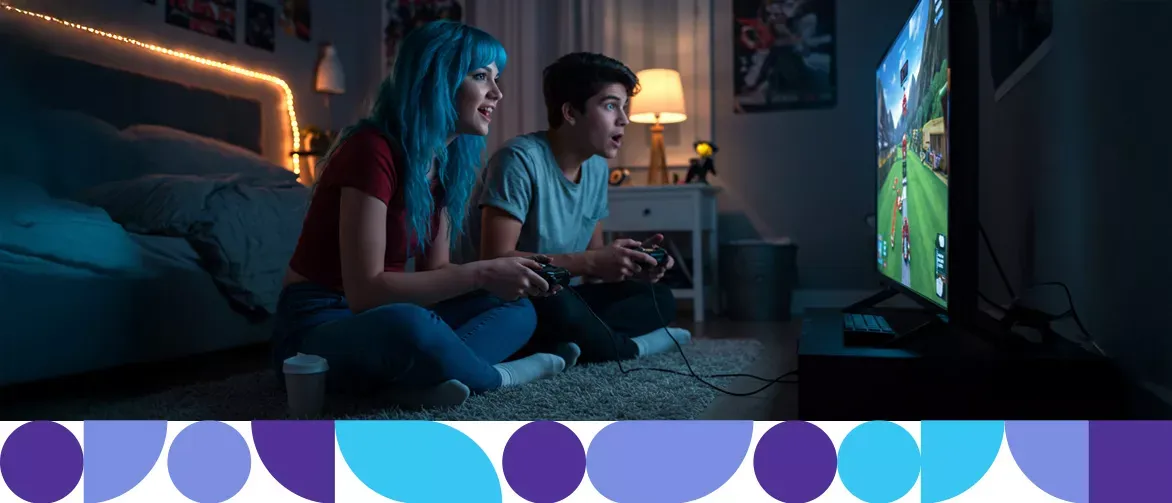 Two friends excitedly playing video games on the tv.