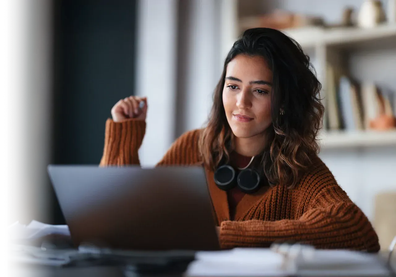 Young female engaging into her laptop with deep concentration.