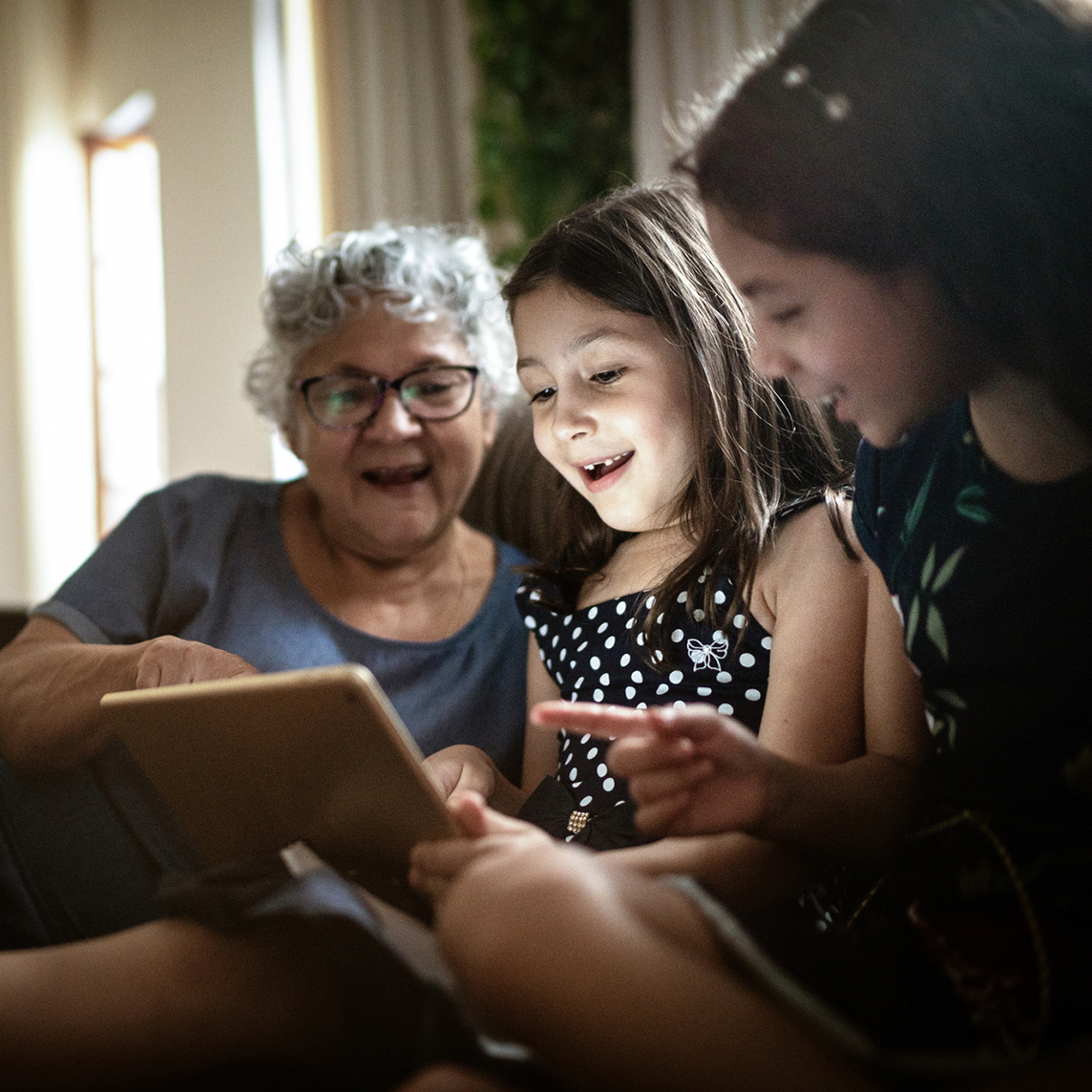 grandmother and daughters with ipad
