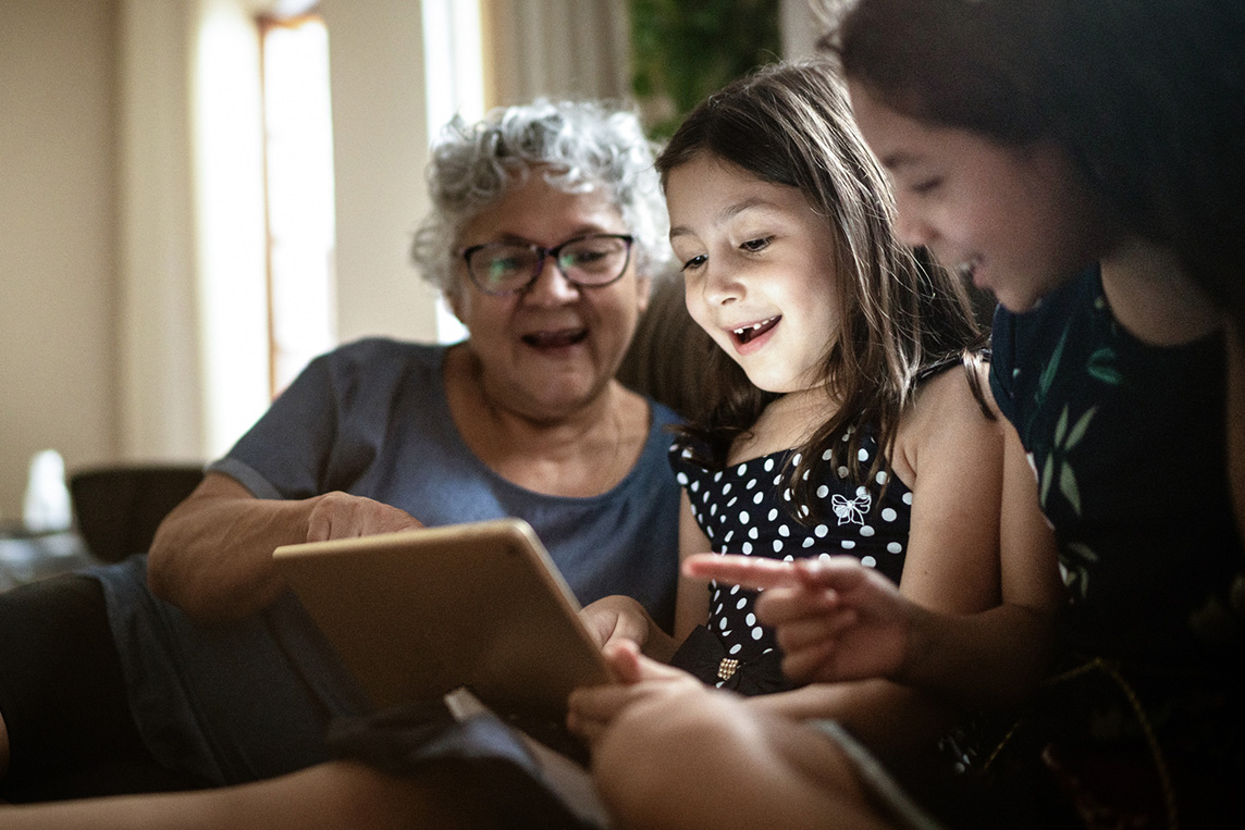 grandmother and daughters with ipad