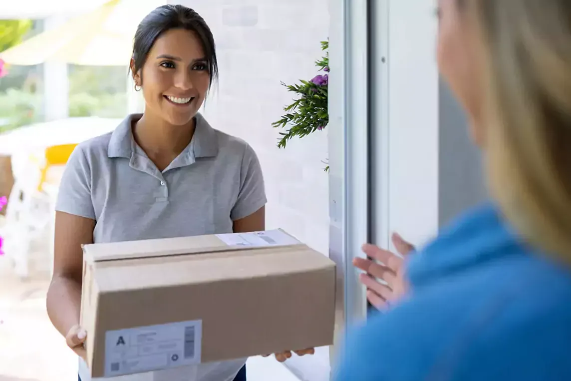 Woman delivers a package to a house.