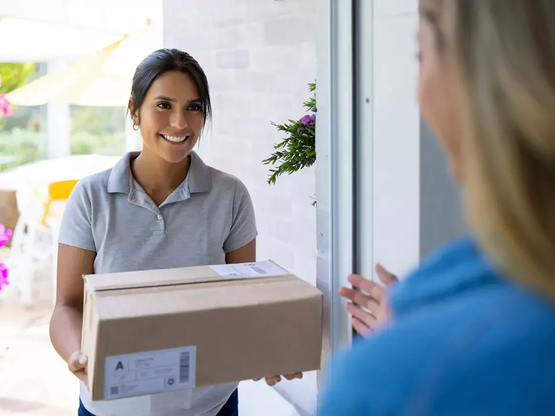 Woman delivers a package to a house.