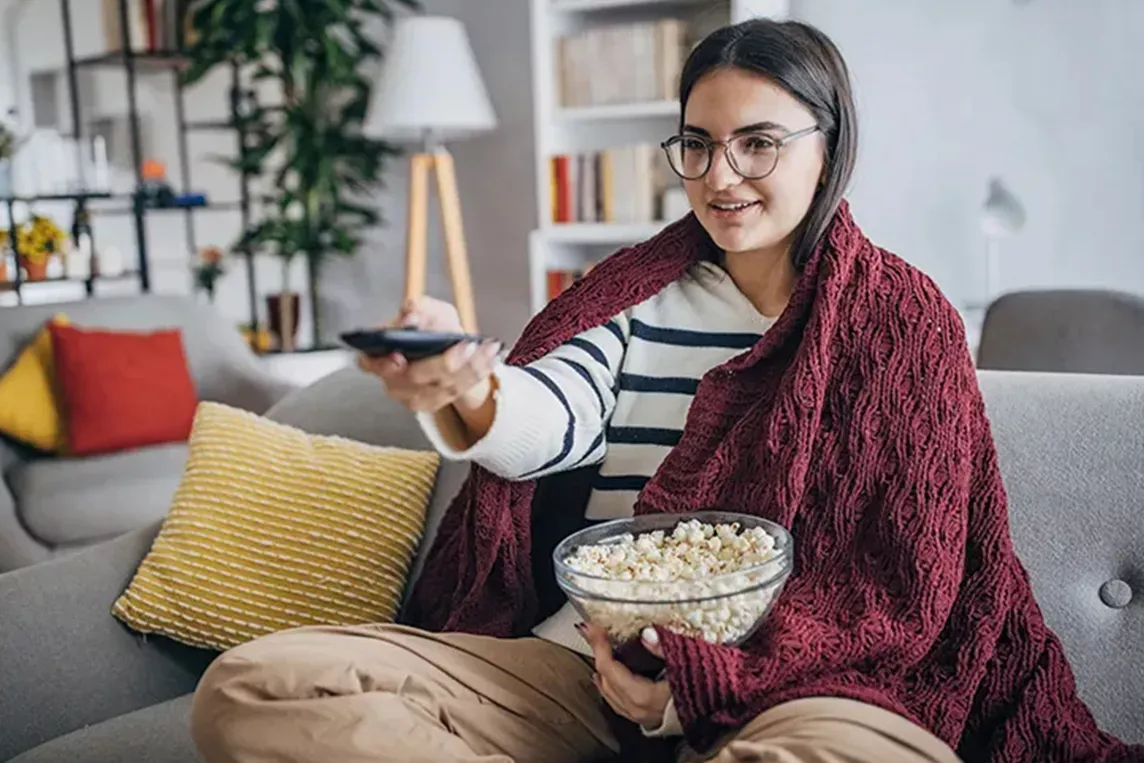 Woman points remote control at TV