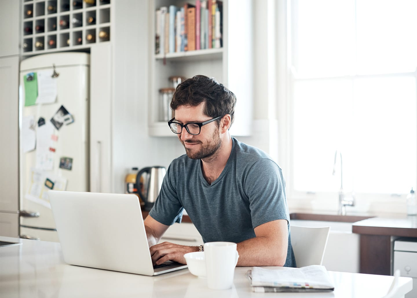 man on laptop at his kitchen table