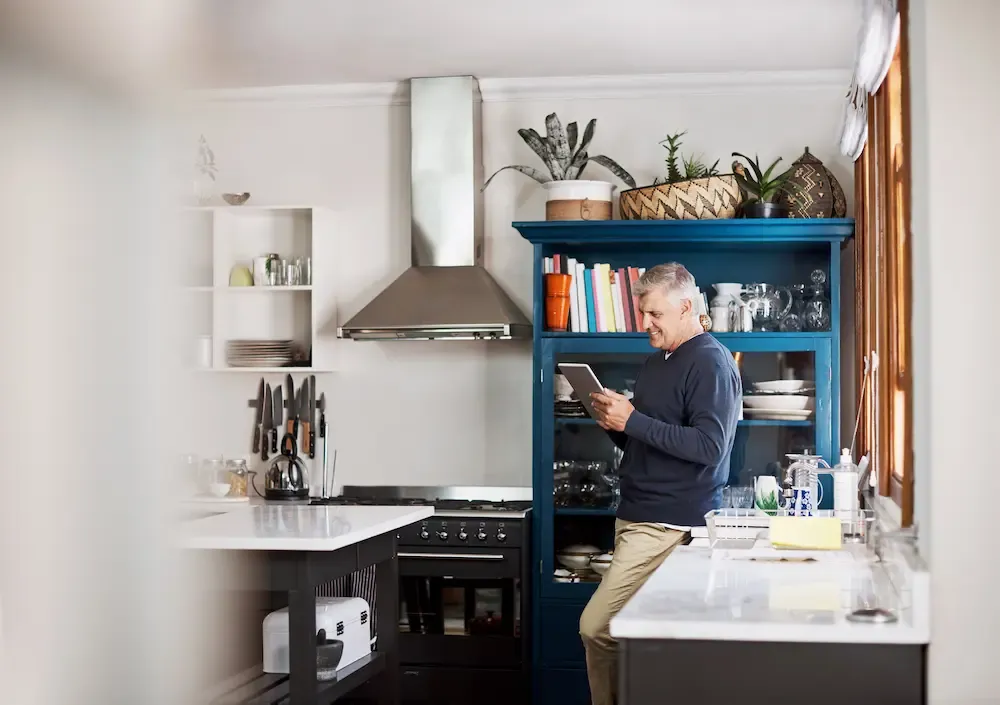 mature man using a digital tablet at home