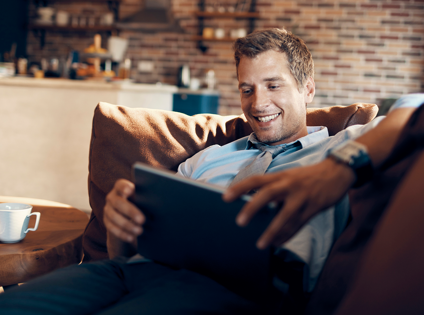 man on couch watching tablet