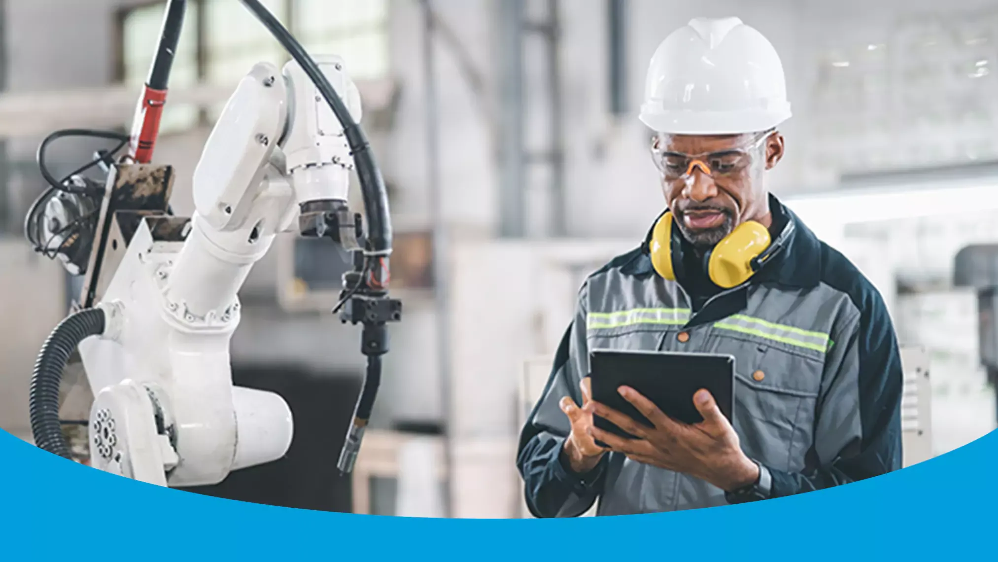 man with white hard hat using tablet at work