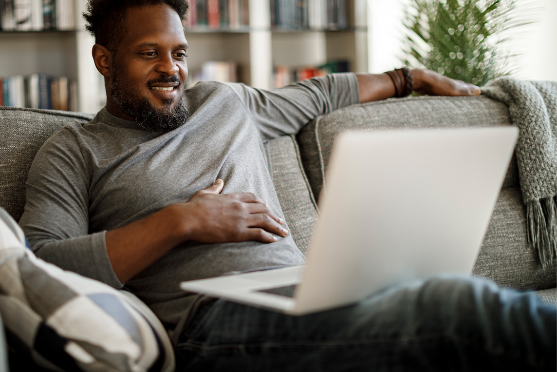 Man using laptop on couch